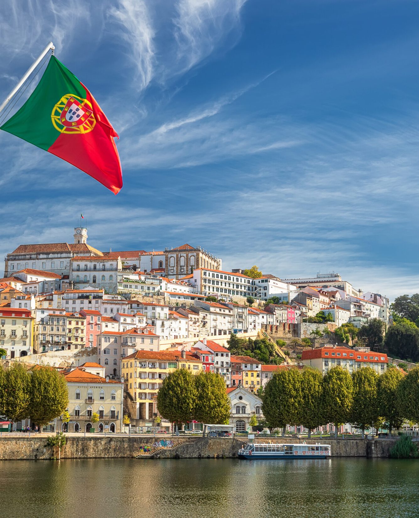 View on the old university city of Coimbra and the medieval capital of Portugal with Portuguese flag. Europe